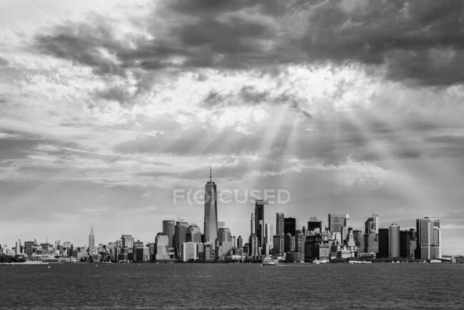 Complesso in bianco e nero di skyline moderni a Manhattan situato di fronte al fiume calmo nella giornata di sole — Foto stock