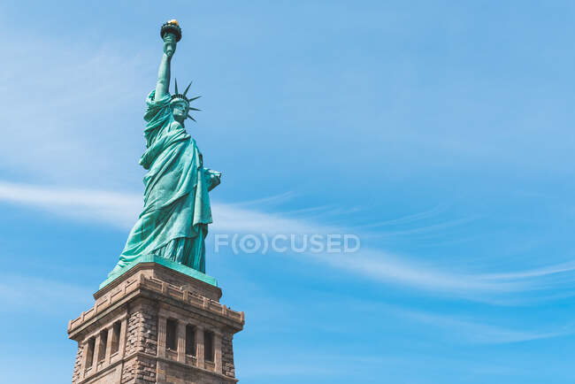 D'en bas de vue spectaculaire de cuivre Statue de la Liberté sur l'île de la Liberté par une journée ensoleillée — Photo de stock