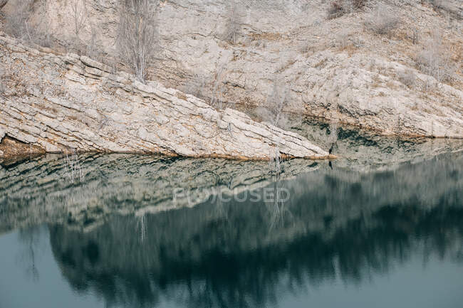 Magnifico paesaggio di lago calmo con superficie d'acqua specchiata circondato da aspre montagne rocciose di Montsec Range coperto in giornata fredda in Spagna — Foto stock