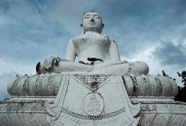 Baixo ângulo de grande monumento de pedra de Buda no fundo do céu nublado — Fotografia de Stock