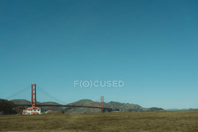 Famosa suspensão Golden Gate Bridge em San Francisco, na Califórnia, com costa montanhosa e céu azul claro no fundo em dia ensolarado — Fotografia de Stock