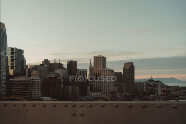Современный район Сан-Франциско с современными высотными зданиями и небоскребами против серого облачного неба во время восхода солнца — стоковое фото