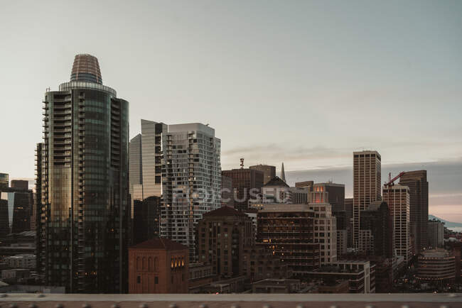 Quartier contemporain de la ville de San Francisco avec des immeubles modernes de grande hauteur et des gratte-ciel contre le ciel gris nuageux pendant le lever du soleil — Photo de stock
