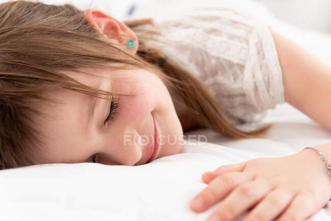 Linda chica relajándose en la cama - foto de stock