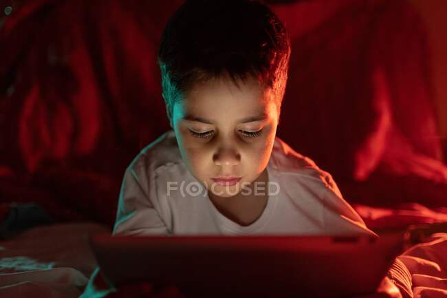 Чудовий хлопчик дивиться мультфільм на планшеті — стокове фото