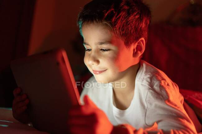Чудовий хлопчик дивиться мультфільм на планшеті — стокове фото