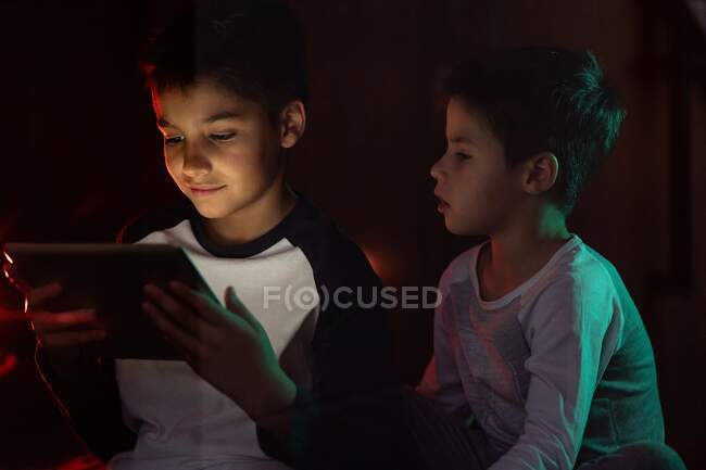 Irmãos bonitos assistindo desenhos animados no tablet juntos — Fotografia de Stock