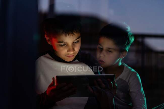 Linda hermanos viendo dibujos animados en la tableta juntos - foto de stock