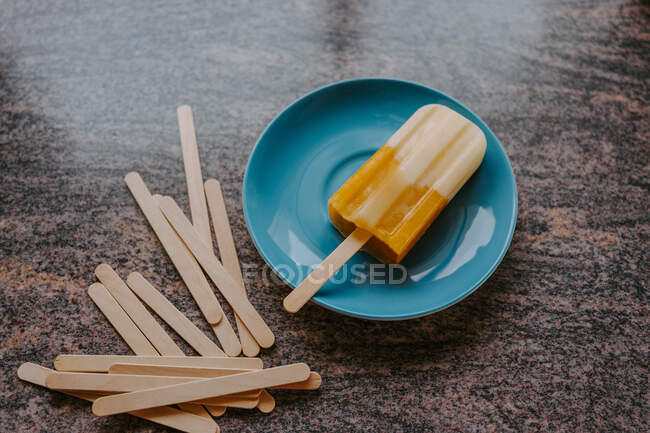 Draufsicht auf köstliches Eis am Stiel aus Früchten, das mit Holzstäbchen auf den Tisch gestellt wird — Stockfoto