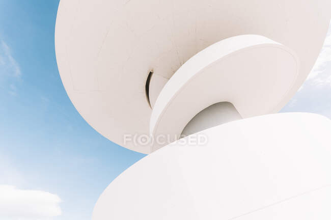 Visão de ângulo baixo de estrutura espiral de concreto branco de edifício de torre de Oscar Niemeyer Centro Cultural Internacional em Espanha contra céu azul nublado — Fotografia de Stock