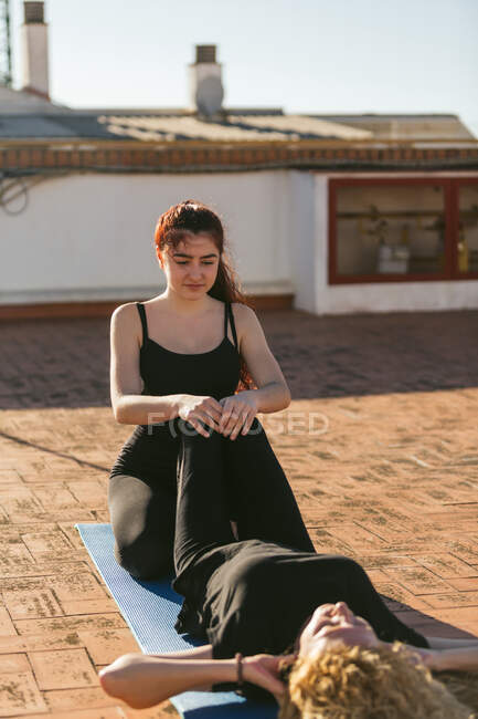 Femmes pratiquant le yoga partenaire sur le toit — Photo de stock