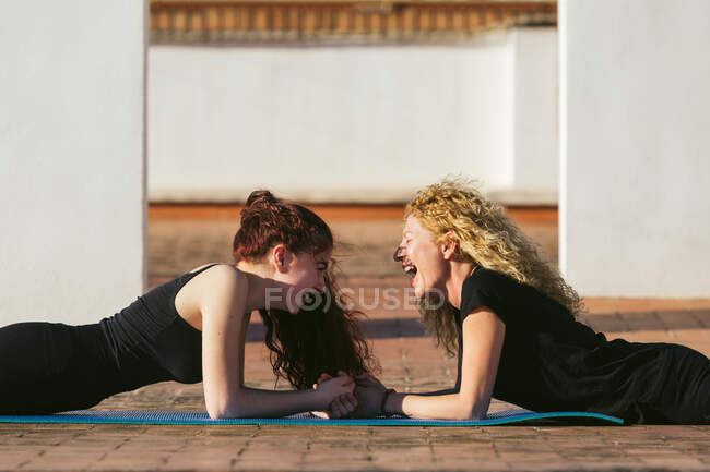 Mulheres magras fazendo prancha pose durante a prática de ioga — Fotografia de Stock