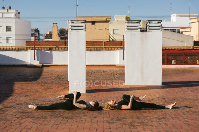Women practicing supine yoga pose together — Stock Photo