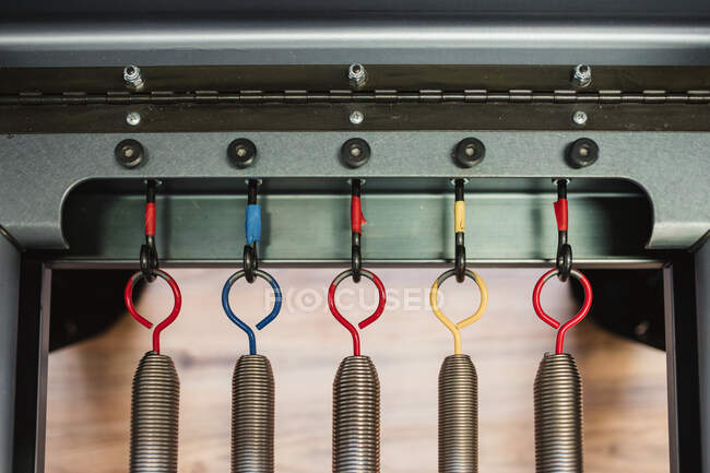 Vue de dessus des ressorts métalliques sur crochets de pilates modernes réformateur placé dans la salle de gym — Photo de stock
