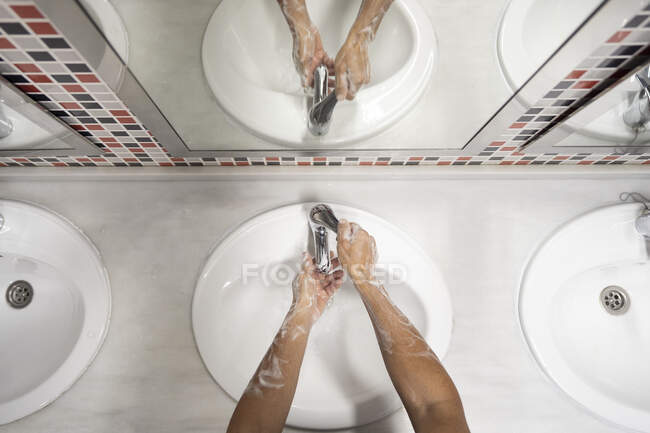 Vista dall'alto di anonime mani di lavaggio maschili con schiuma nel lavandino durante l'epidemia di coronavirus — Foto stock