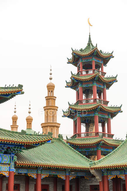 Vue à angle bas de la pagode et du temple musulman avec ciel couvert — Photo de stock