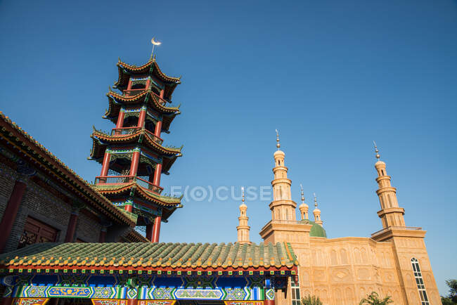 Низкий угол обзора пагоды и мусульманского храма с голубым небом — стоковое фото