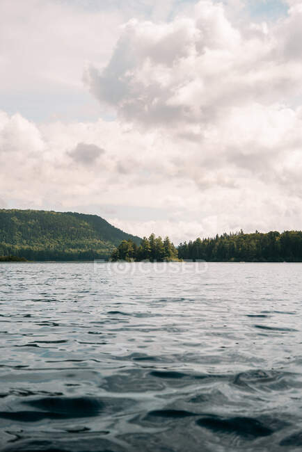 Pittoresca veduta del lago calmo in mezzo alla foresta con alberi verdi contro il cielo nuvoloso nel Parco Nazionale La Mauricie in Quebec, Canada — Foto stock