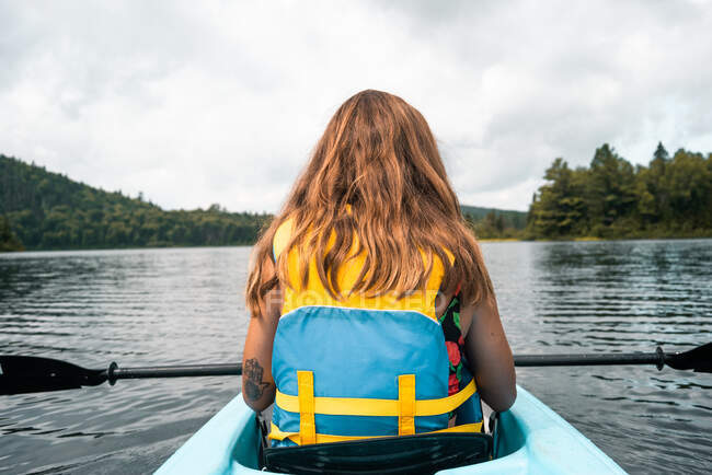 Погляд на анонімну жінку - мандрівника в житті, що сидить у човні під час річкових досліджень проти хмарного неба у Національному парку Ла - Маурічі (Квебек, Канада). — стокове фото