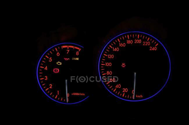 Panel de instrumentos de coche con iluminación de neón en pantalla digital con indicadores e información sobre la velocidad - foto de stock