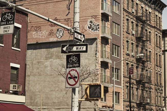 Unterhalb von Einbahnstraßen-Verkehrsschildern an einer Kreuzung mit modernen Hochhäusern im Hintergrund in New York City — Stockfoto