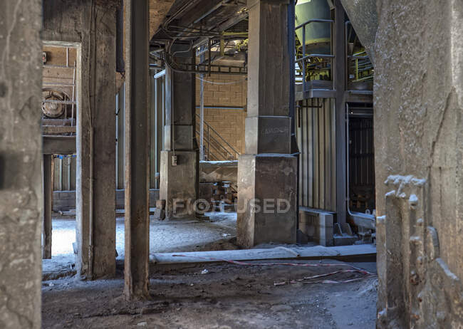 Worn out passage in building with aged walls and dirty cement located on old factory without windows and doors — Foto stock