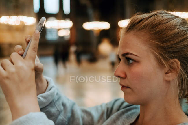 Під час екскурсії по Стамбулу на смартфон стоїть і фотографується серйозна жінка. — стокове фото