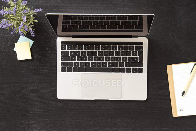 Сверху ноутбука, размещенного на черном столе — стоковое фото
