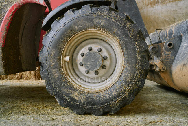 Dirty tractor wheel in garage on farm — Fotografia de Stock