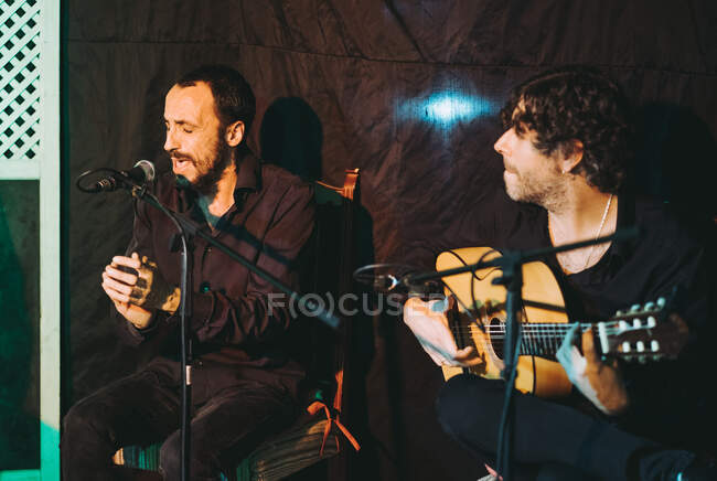 Musicista ispanico adulto applaude mentre canta una canzone di flamenco sul palco — Foto stock