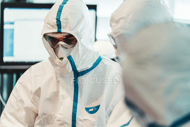 Médecin professionnel sérieux en uniforme de protection et masque debout dans la salle d'opération moderne — Photo de stock