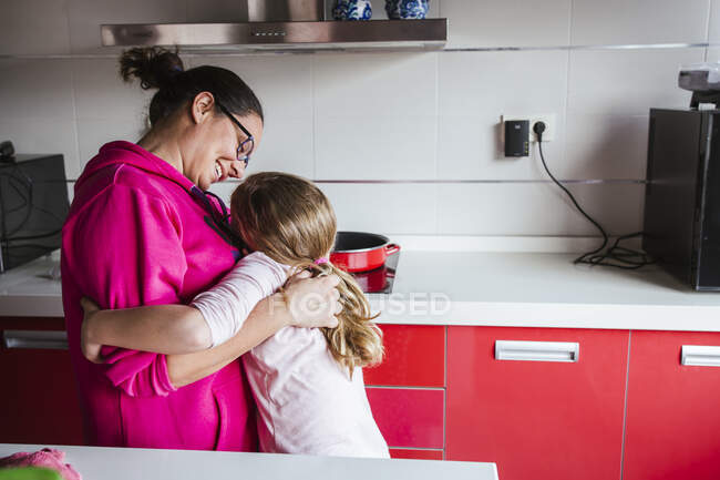 Filha perturbada abraçando a mãe em casa — Fotografia de Stock