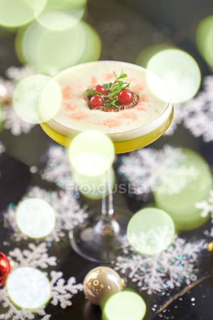 Foto vertical de estoque de um copo redondo de coquetel mezcal com kiwi e xarope de bordo com mesa decorada com estrelas de neve — Fotografia de Stock