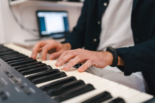 Cortar músico masculino tocando piano elétrico e compondo música em estúdio criativo em casa — Fotografia de Stock