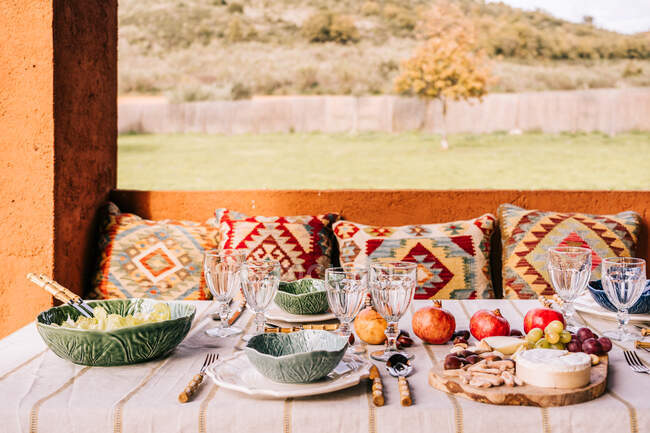 Table served with tableware and assorted ripe fruits and delicious appetizers on terrace — Stock Photo