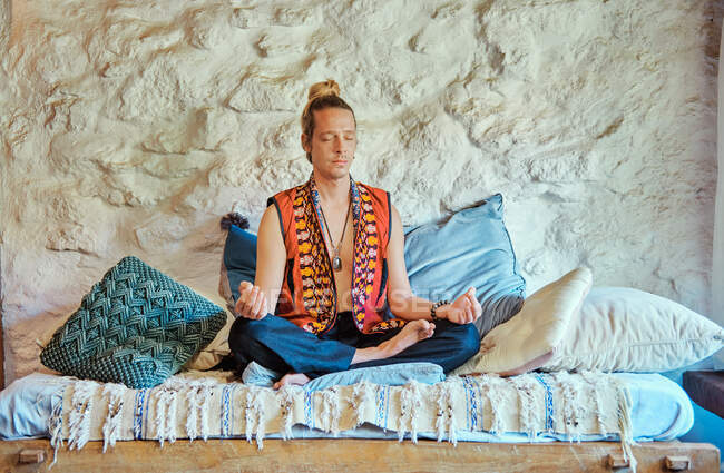 Homem loiro praticando meditação com os olhos fechados em casa — Fotografia de Stock