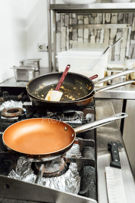 Dall'alto pentole sporche vuote dopo aver preparato il piatto su stufa in cucina di ristorante — Foto stock