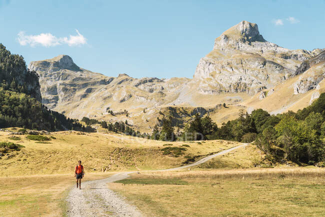 Віддалені види туристів, які ходять піщаною дорогою в сонячний день у горах Піренеїв. — стокове фото