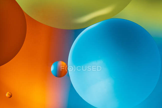 Primo piano di sfondo astratto con cellule rotonde sagomate di vaccino di diverse dimensioni illuminate da luce colorata — Foto stock