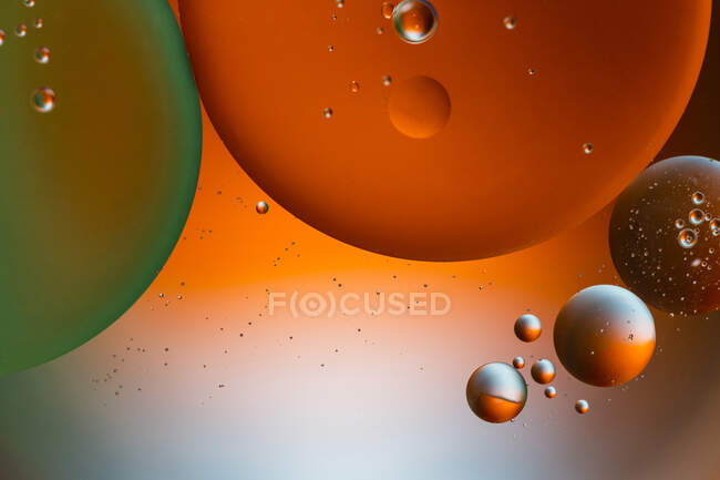 Primo piano di sfondo astratto con cellule rotonde sagomate di vaccino di diverse dimensioni illuminate da luce colorata — Foto stock