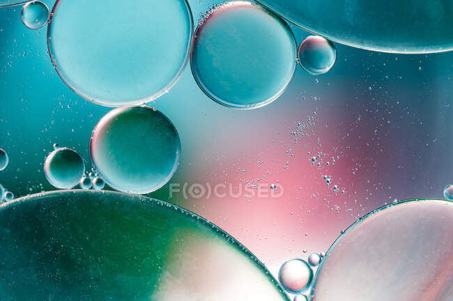 Primer plano de fondo abstracto con células redondas de vacuna de diferentes tamaños iluminadas por luz colorida - foto de stock