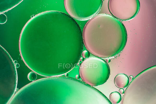 Primer plano de fondo abstracto con células redondas de vacuna de diferentes tamaños iluminadas por luz colorida - foto de stock