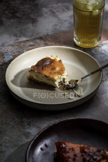 Зверху апетитний пиріг кладуть на керамічну тарілку зі склянкою напою з льодом в ресторані — стокове фото