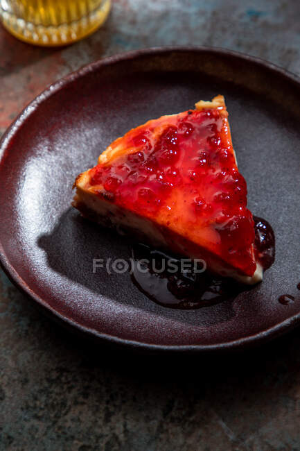 From above of appetizing pie wit berry jam placed on ceramic plate with glass of drink with ice in restaurant — Stock Photo