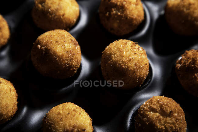 Alto ângulo de saborosas bolas de queijo torrado na assadeira na mesa de concreto na cozinha — Fotografia de Stock