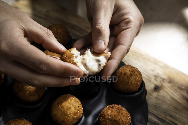 De cima da colheita chef anônimo demonstrando enchimento de bola de queijo em crosta crocante na cozinha — Fotografia de Stock