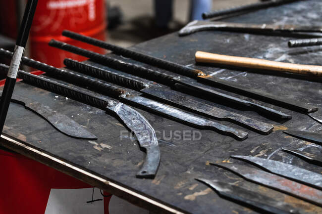 Linhas de vários instrumentos metálicos colocados na mesa em ferreiro — Fotografia de Stock