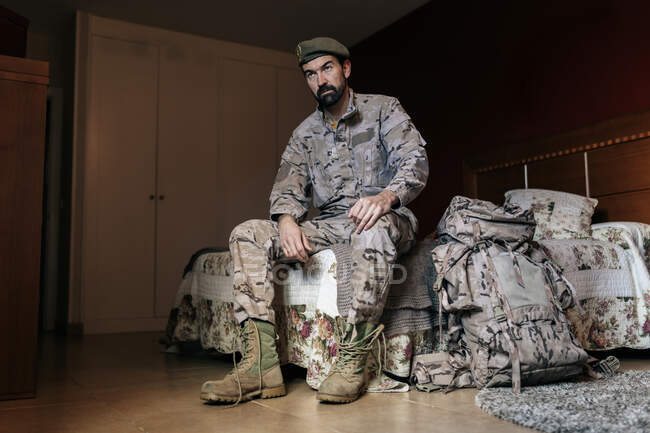 Baixo ângulo de homem sério em uniforme militar se preparando para servir em militares — Fotografia de Stock