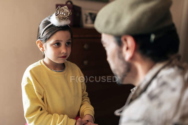 Військовий батько тримає руки маленької дівчинки перед тим, як піти захищати країну — стокове фото