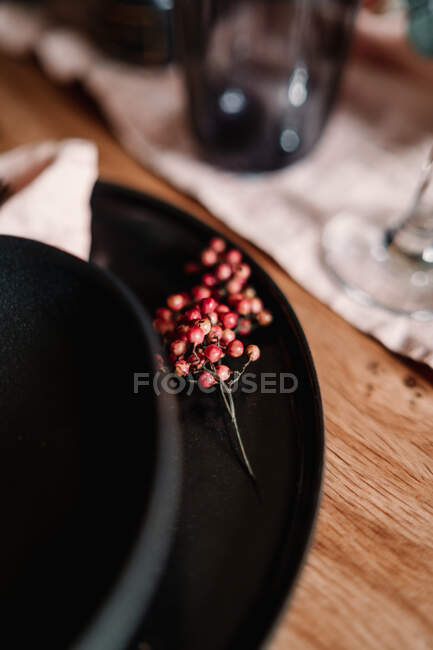 High angle of plate with bowl and bundle of small decorative berries during festive occasion in restaurant — Stock Photo